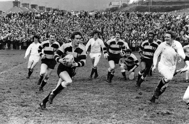 Just look at that crowd! Cardiff flanker Stuart Lane makes an early probe, but Swansea's defence is alert to the danger during a packed derby in 1978.